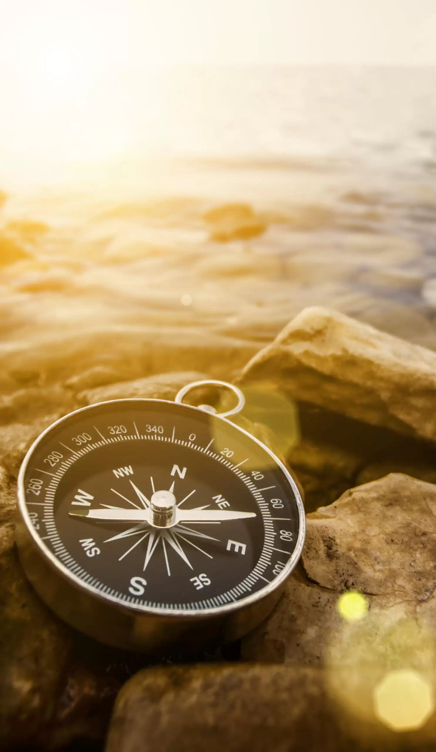 compass on the shore at sunrise
